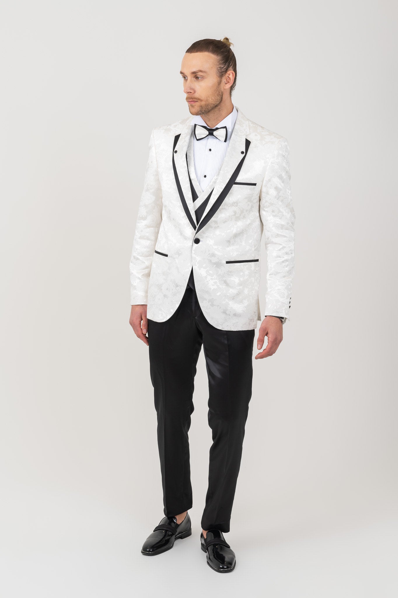 Detail of black mono lapel on a men's white tuxedo suit