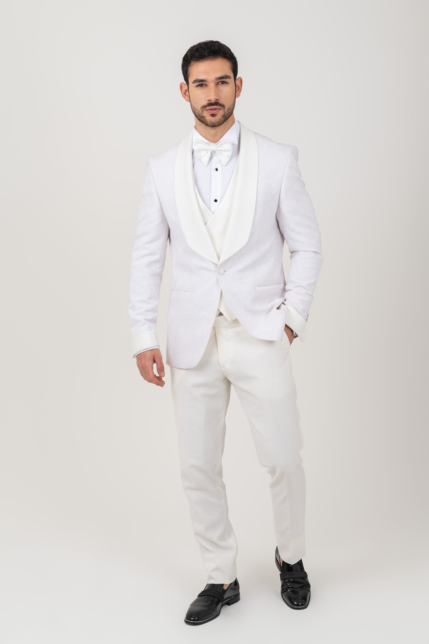 White jacquard tuxedo suit with lapels and a bow tie. Perfect for formal occasions.