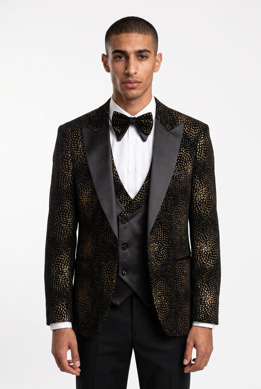 Man wearing a gold starburst velvet tuxedo with a satin peak lapel and double breasted waistcoat