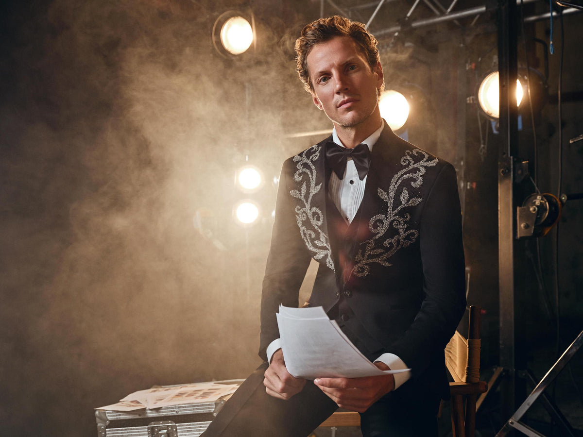Men in black patterned tuxedos with bow ties, styled for Christmas party season