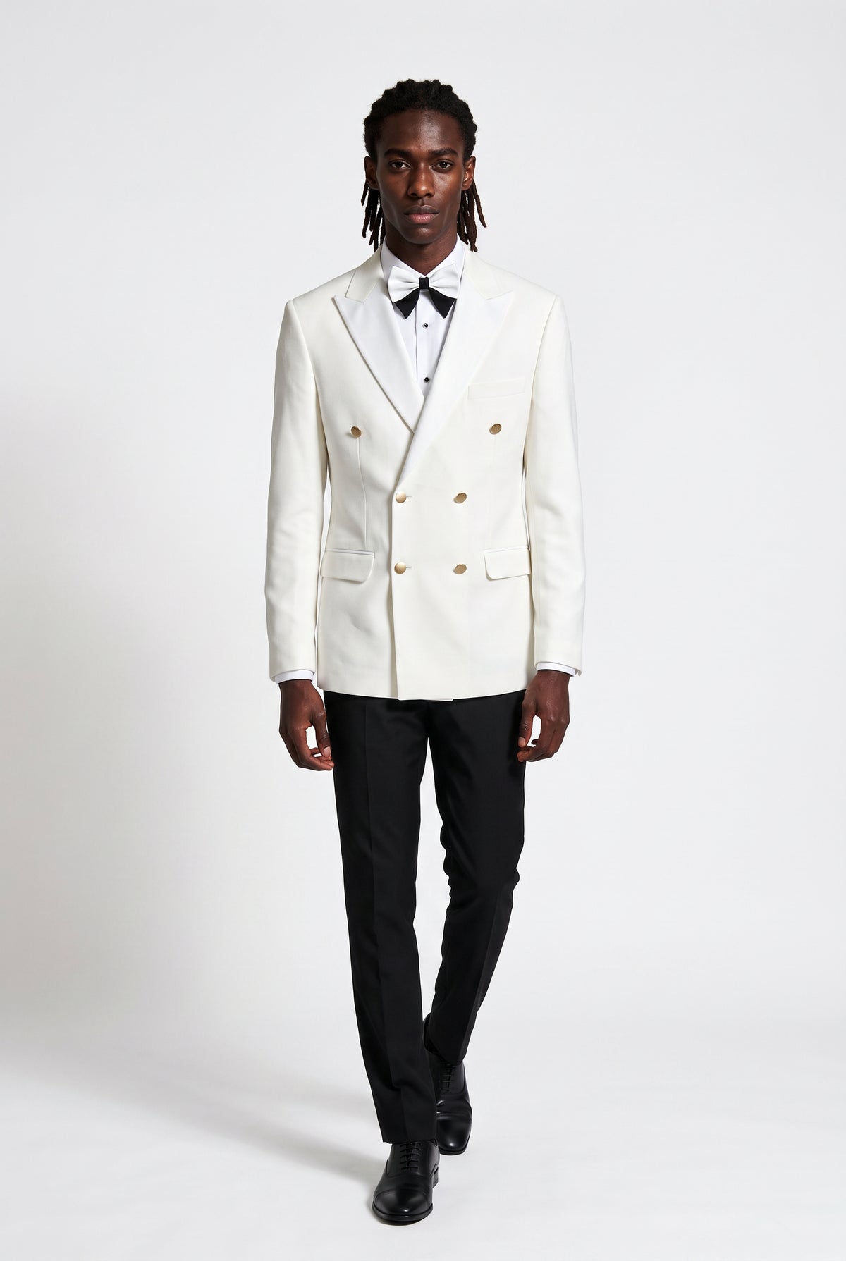 Man wearing a white double breasted peak lapel tuxedo with black trousers
